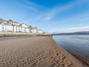 a sandy beach with houses and the water at Pebble Cottage - Uk32243 in Aberdyfi