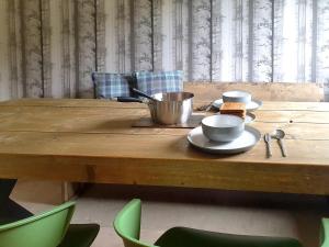 a wooden table with bowls and cups on it at Ferry Cottage in Pitlochry
