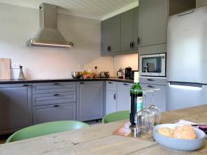 a kitchen with a table with a bottle of wine at Ferry Cottage in Pitlochry