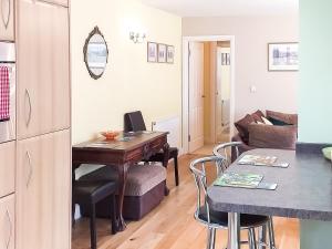 a kitchen and living room with a desk and a couch at Little Acorns in Great Malvern