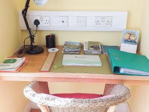 a desk with a chair and books on it at Little Acorns in Great Malvern