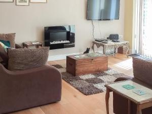 a living room with a couch and a tv at Little Acorns in Great Malvern