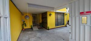 żółty budynek z tabliczką zakazującą palenia w obiekcie Hotel Villas de San Juan, Guatemala w mieście Gwatemala