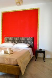 Un dormitorio con una pared roja y una cama en SottoSopra en Margherita di Savoia