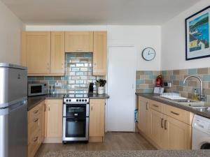 a kitchen with wooden cabinets and a stove top oven at The Mews Apt 1 Newcomen Road in Dartmouth