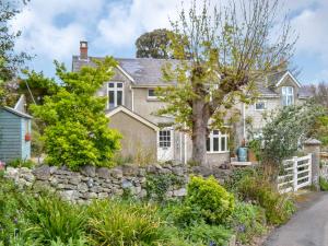 ein Haus mit einer Steinmauer und einem Baum in der Unterkunft Elm Cottage in Whitwell