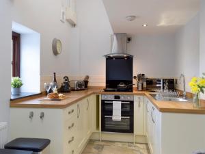 a kitchen with a sink and a stove top oven at Snowdrop Cottage - Uk12987 in Monington