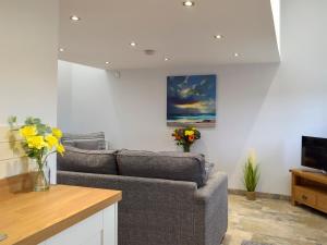 a living room with a couch and a tv at Snowdrop Cottage - Uk12987 in Monington