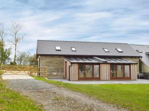 a stone house with a gambrel roof and windows at Snowdrop Cottage - Uk12987 in Monington