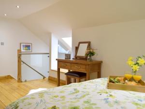 a bedroom with a bed and a desk with a mirror at Snowdrop Cottage - Uk12987 in Monington