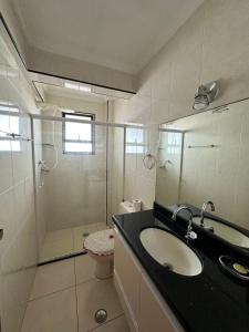 a bathroom with a sink and a shower at Lindo apartamento de frente ao mar in Praia Grande