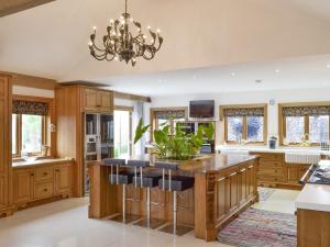 a kitchen with a large island with bar stools at Carr End Barn A in Preesall