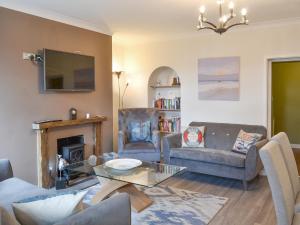 a living room with a couch and a table at Prudhoe Mews in Alnmouth