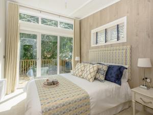 a bedroom with a bed and a large window at Beach Retreat in Corton