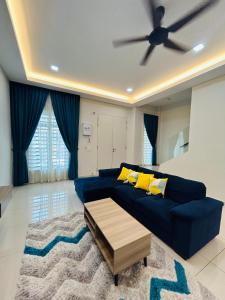 a living room with a blue couch and a ceiling fan at Insyirah Homestay Melaka in Malacca