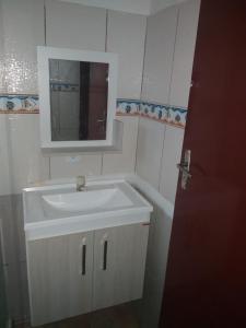 a bathroom with a white sink and a mirror at Casa de Praia Completa em Cabo Frio 04 para até 5 Pessoas in Cabo Frio