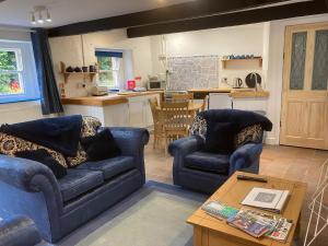 una sala de estar con 2 sofás azules y una mesa. en The Old Tearoom-uk32945, en Great Salkeld
