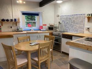 una cocina con mesa de madera y sillas. en The Old Tearoom-uk32945, en Great Salkeld