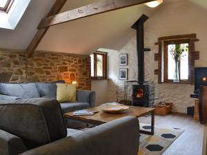 a living room with a couch and a fireplace at The Old Coach House in Woolfardisworthy
