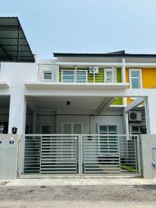 Uma casa branca com um portão à frente. em Insyirah Homestay Melaka em Malaca