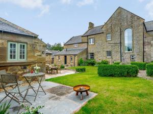a garden with a table and chairs and a building at The Stable - Uk35021 in Long Houghton