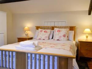 a bedroom with a bed with a wooden headboard and pillows at Dardy Cottage in Crickhowell