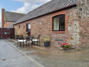 a patio with a table and chairs in front of a building at Th Hollow in Bishops Lydeard