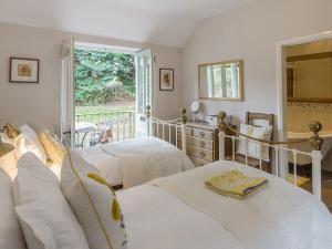 1 dormitorio con 2 camas, escritorio y ventana en Walkmill Lodge, en Wentnor