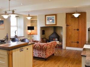 ein Wohnzimmer mit einem Sofa und einem Kamin in der Unterkunft Cranford House in Woolfardisworthy