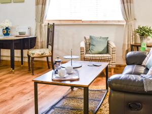 a living room with a coffee table and chairs at Lower West in Newnham