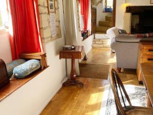 a living room with a couch and a table at Driftcombe Farmhouse in Bisley