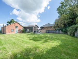 a large yard with a brick house and a grass field at The Old Dairy in Wroxall