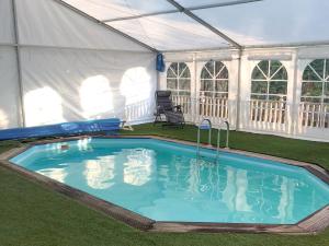 a large swimming pool in a marquee with at The Tranquil Orchard - Woodpecker-uk31339 in Mouswald