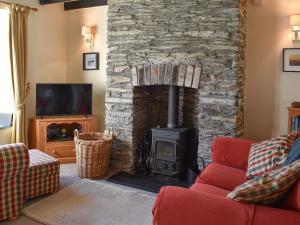 - un salon avec une cheminée en pierre et une cuisinière dans l'établissement Squirrel Cottage, à Wadebridge