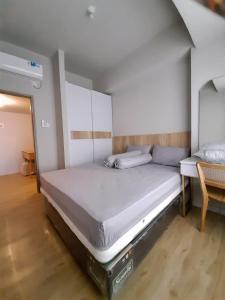 um quarto com 2 camas, uma mesa e uma cama em Newton Residence Apartment bm em Bandung