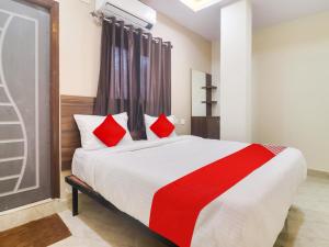 - une chambre avec un grand lit et des oreillers rouges dans l'établissement Red Stone Hotels, à Hyderabad