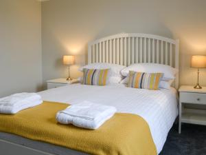 sypialnia z dużym białym łóżkiem z ręcznikami w obiekcie Number Three w mieście Marvig