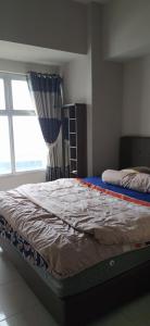 uma cama num quarto com uma janela em Newton Residence Apartment bm em Bandung