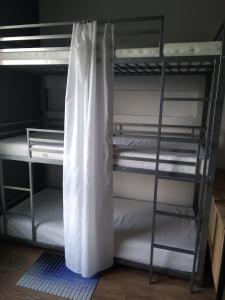 a room with a bunk bed with white sheets at RADLIŃSKA FOLWARK in Kielce