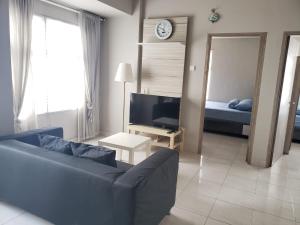 a living room with a couch and a television at Newton Residence Apartment bm in Bandung