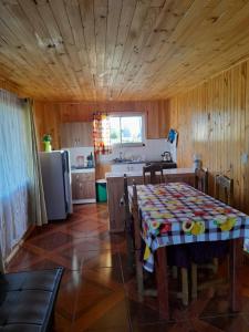 a kitchen with a table and a kitchen with a refrigerator at Cabañas encanto de Chovellen in Pelluhue