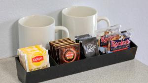 a tray with two coffee mugs and some snacks at CBD GI Motel in Glen Innes