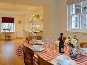 a dining room table with a red and white checked table cloth at Straton Cottage in Saint Cyrus