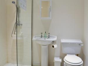 a bathroom with a toilet and a sink and a shower at Straton Cottage in Saint Cyrus