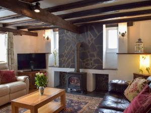 a living room with a fireplace and a couch at The Carthouse - Uk13184 in Cwm-Morgan