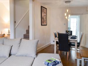 a living room with a couch and a dining room table at Anchor Cottage in Instow