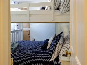 a bedroom with a bunk bed with pillows on it at Anchor Cottage in Instow