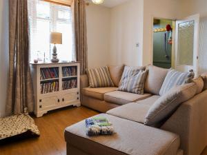 a living room with a couch and a table at Anchor Cottage in Instow