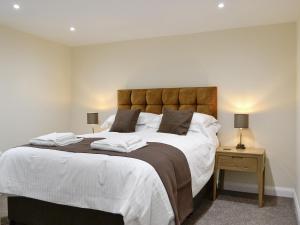 a bedroom with a large bed with two pillows on it at Mary Rook Cottage - Uk1369 in Keswick