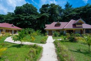 a house with pink roofs and a walkway at Zerof Self Catering Apartments in La Digue